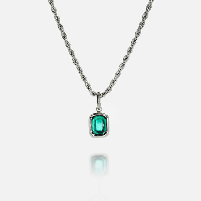 Silver necklace with a rectangular green gemstone pendant on a clean white background, featuring a reflective surface below the pendant