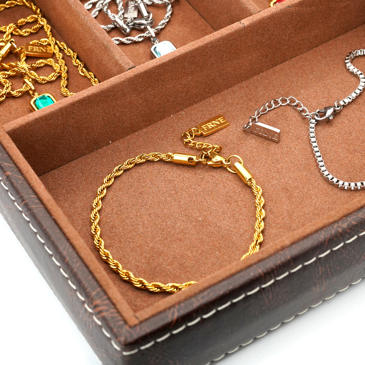 Premium silver and gold bracelets by FRNE displayed in jewellery box minimalist styling