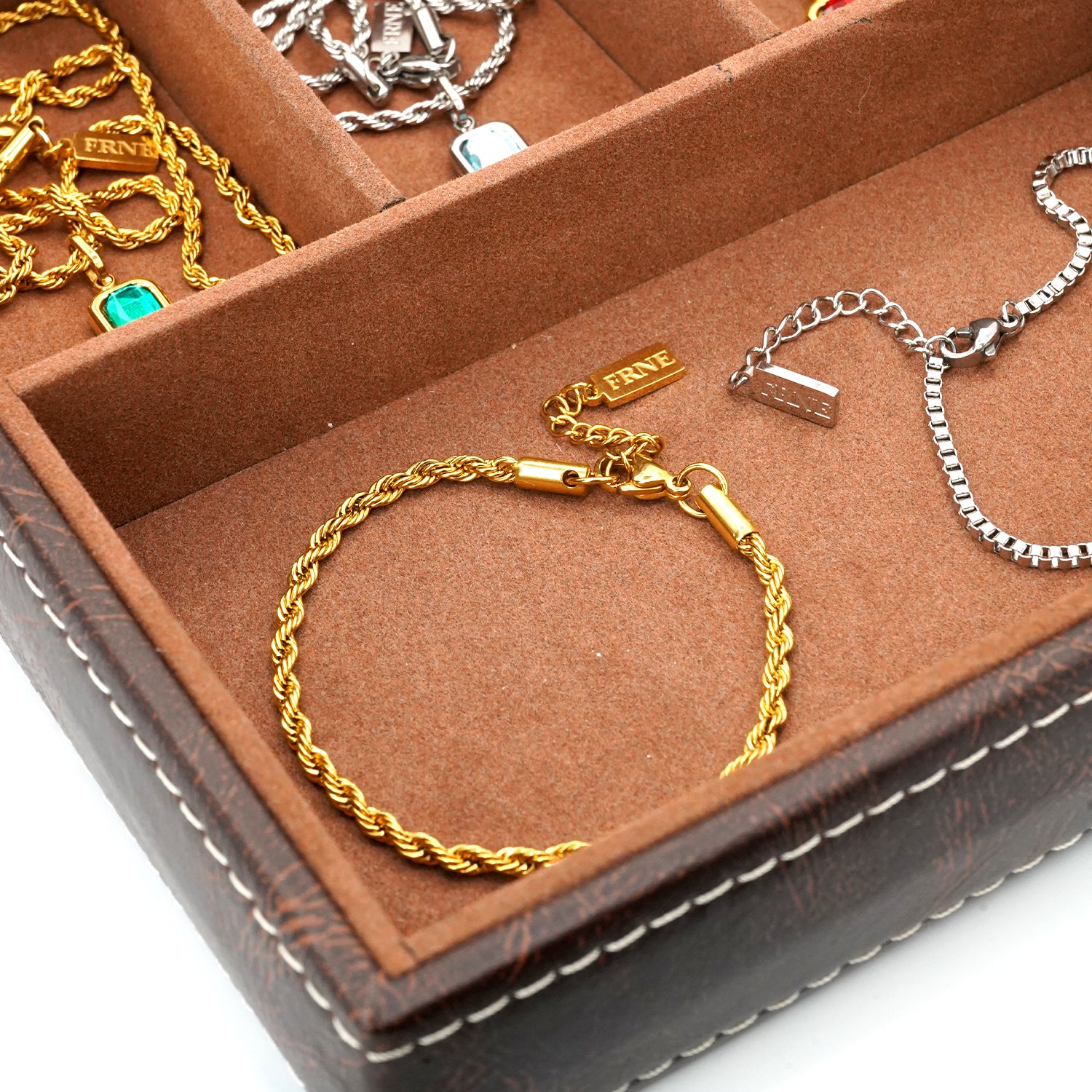 Premium silver and gold bracelets by FRNE displayed in jewellery box minimalist styling