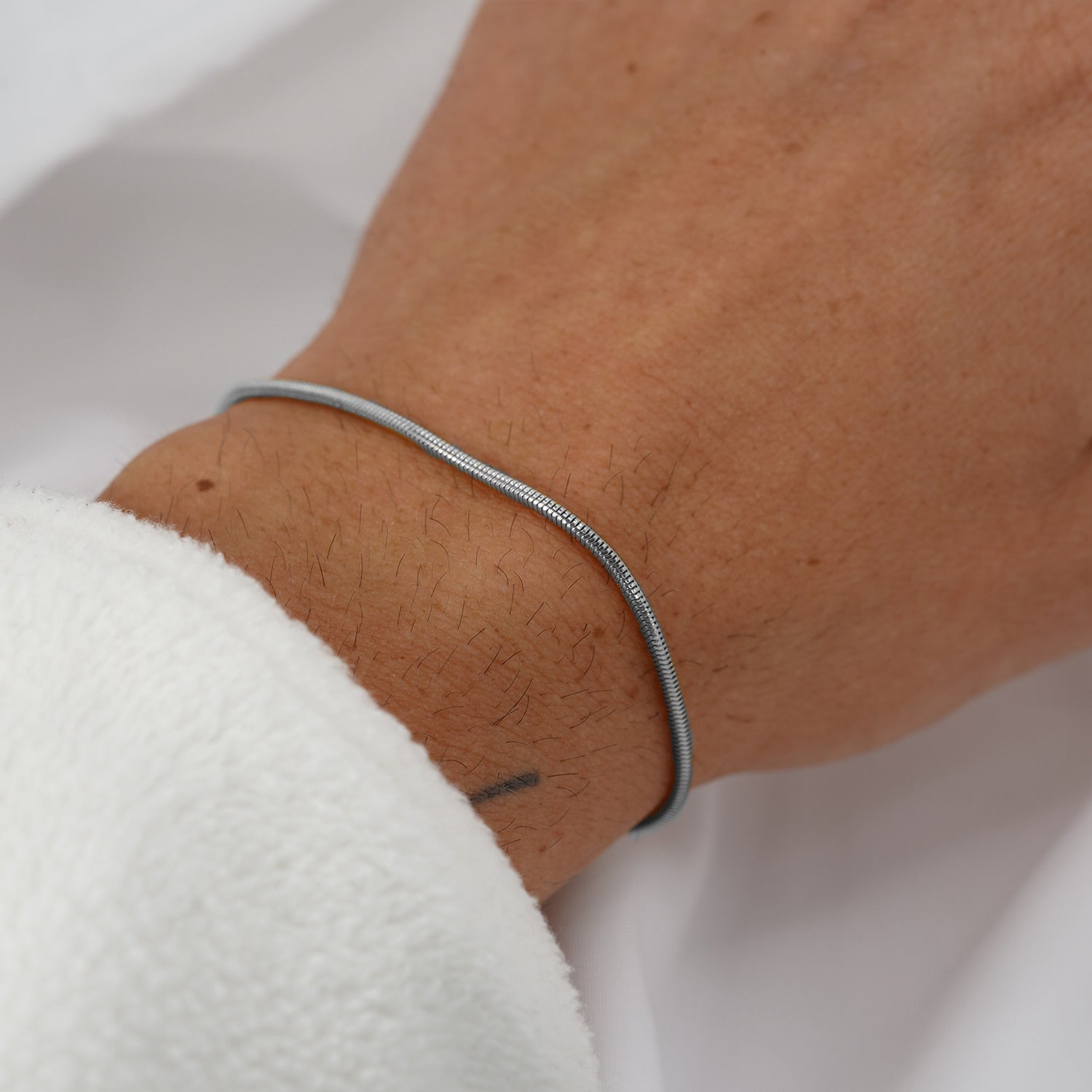 Premium silver snake chain bracelet by FRNE worn on wrist with minimalist everyday style