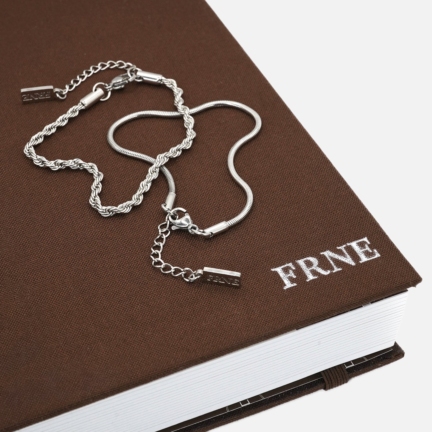 Premium silver snake chain bracelet by FRNE styled on book minimalist jewellery photography