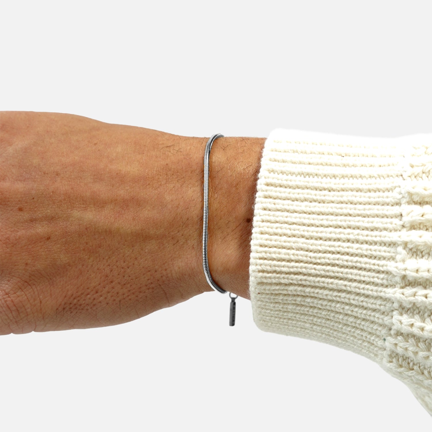 Premium silver snake chain bracelet by FRNE worn on wrist with knit sleeve minimalist style