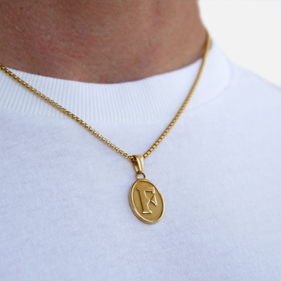 Gold necklace with a pendant on a white shirt