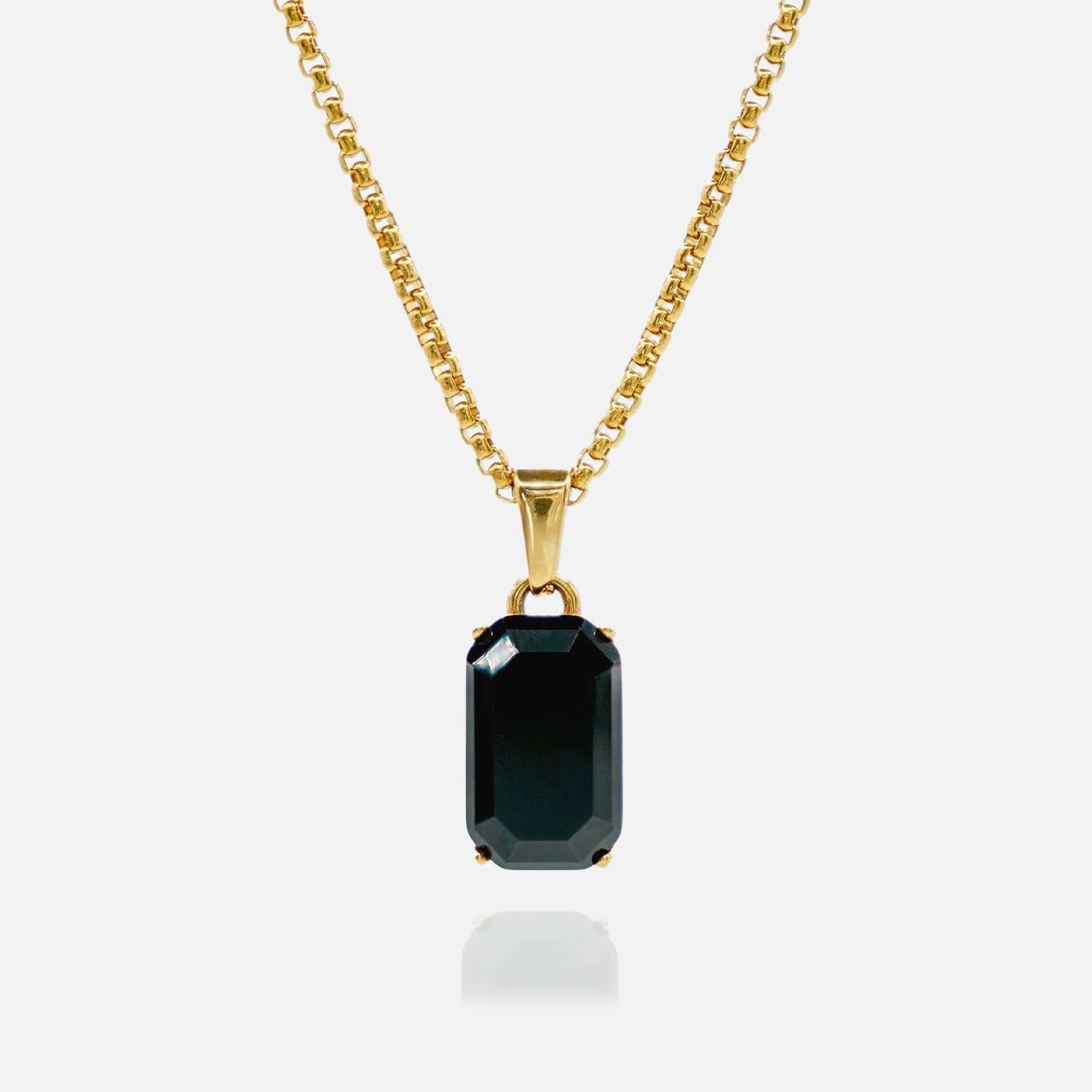 Gold necklace with a black gemstone pendant on a white background