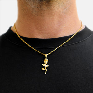 Gold rose pendant necklace on a black shirt against a white background