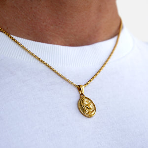 Gold necklace with a pendant on a white background