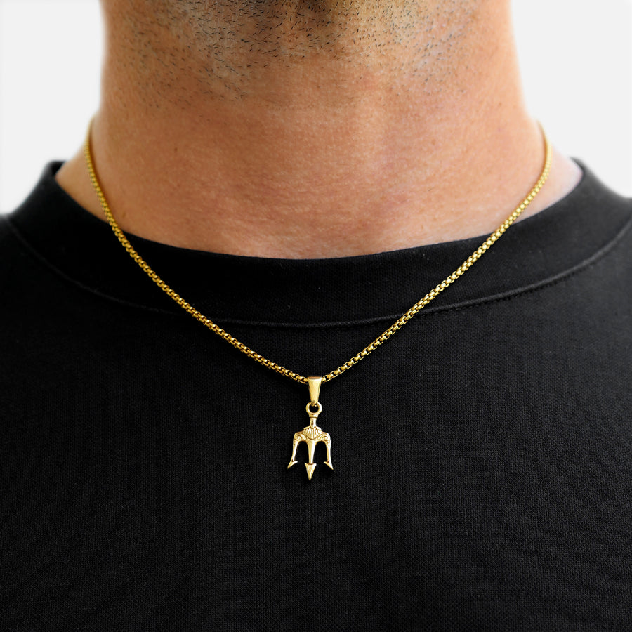 Gold necklace with a pendant on a black shirt against a white background