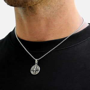 Person wearing a black shirt with a silver necklace featuring a pentacle pendant.