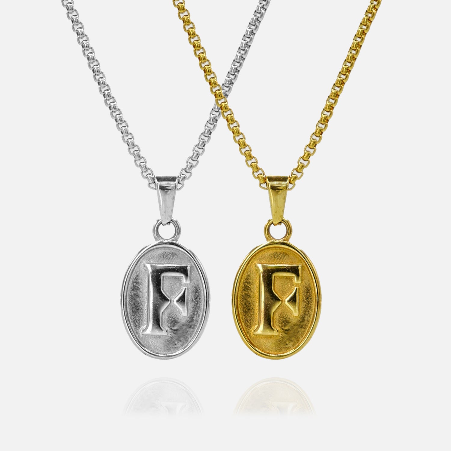 Two necklaces with oval pendants featuring the letter 'F', one in silver and one in gold, on a white background.