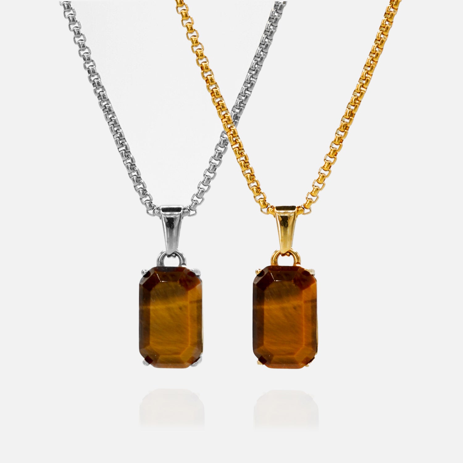 Two amber pendant necklaces on gold and silver chains against a white background