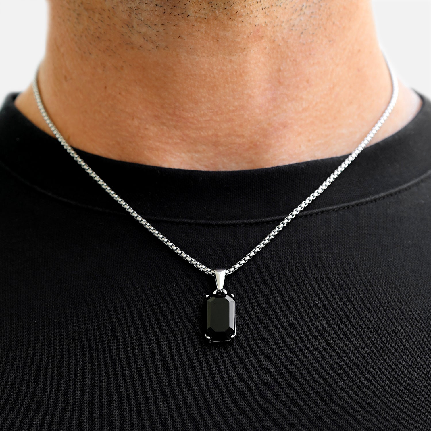Black pendant necklace on a person wearing a black shirt
