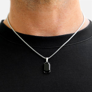 Black pendant necklace on a person wearing a black shirt