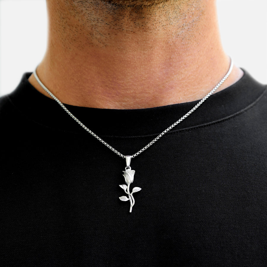 Silver rose pendant necklace on a black shirt