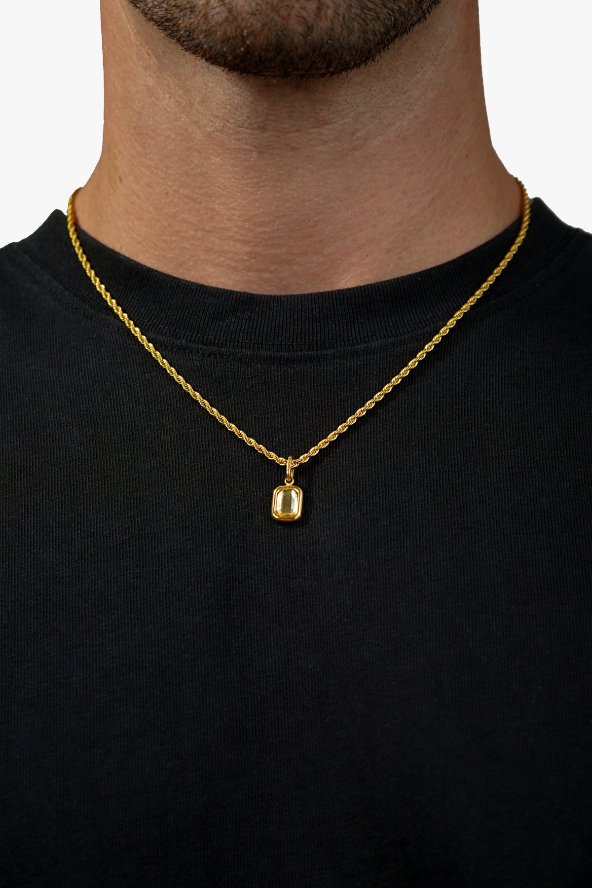 FRNE citrine gemstone gold pendant necklace with rectangular yellow stone worn on neck with black shirt in clean studio close up shot