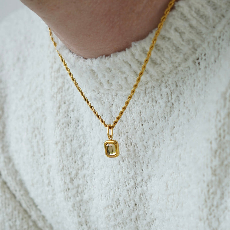FRNE citrine gemstone gold pendant necklace with rectangular yellow stone worn on neck with white sweater in close up lifestyle shot
