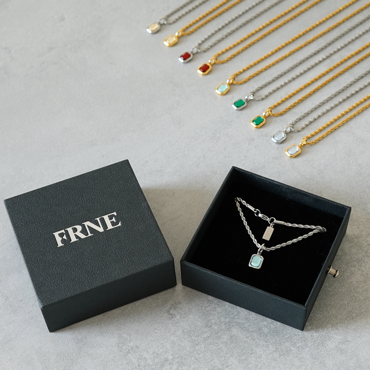 FRNE sterling silver gemstone pendant necklace in gift box with gold and silver necklace collection on background