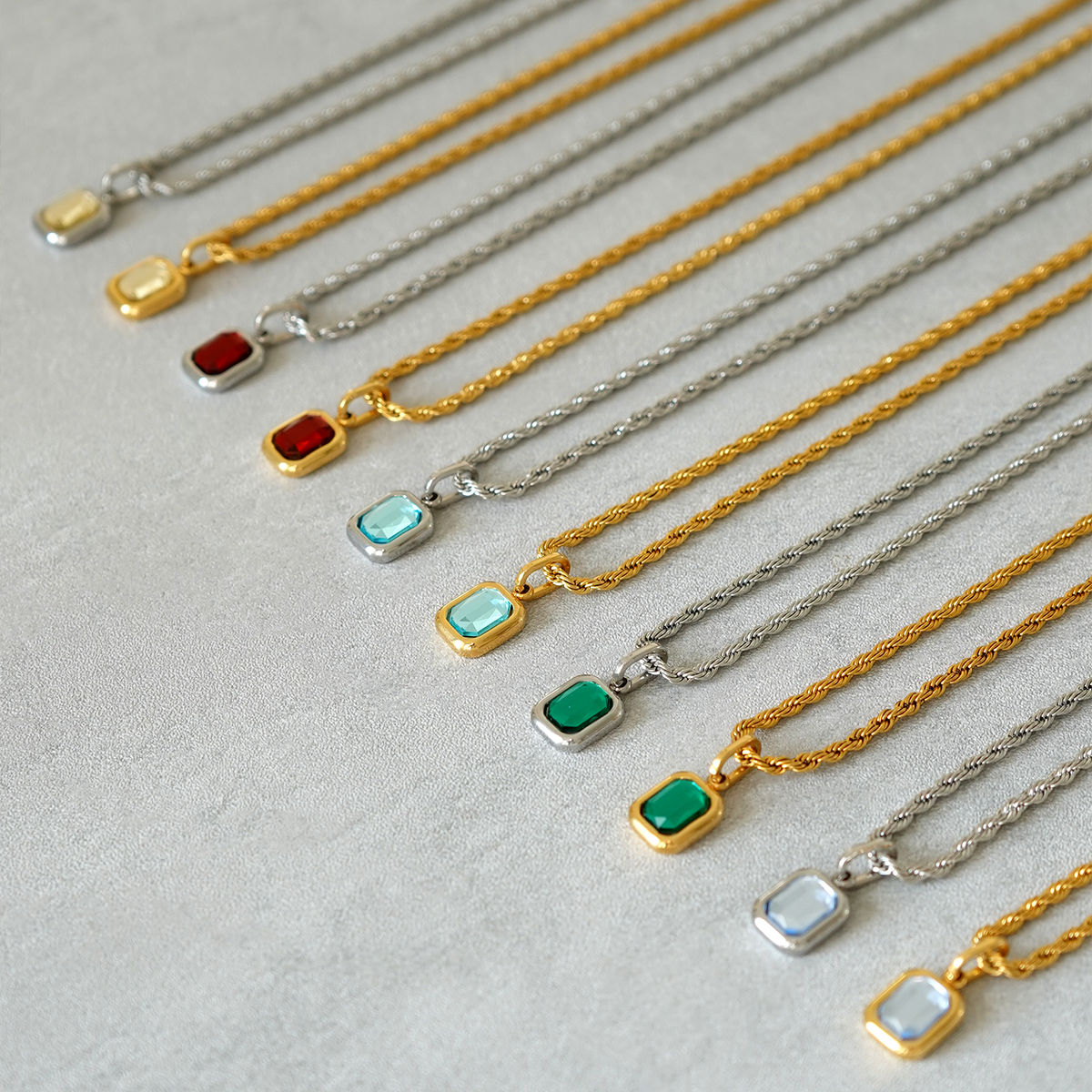 FRNE gold and sterling silver gemstone pendant necklaces flat lay with multiple colored rectangular stones on neutral background