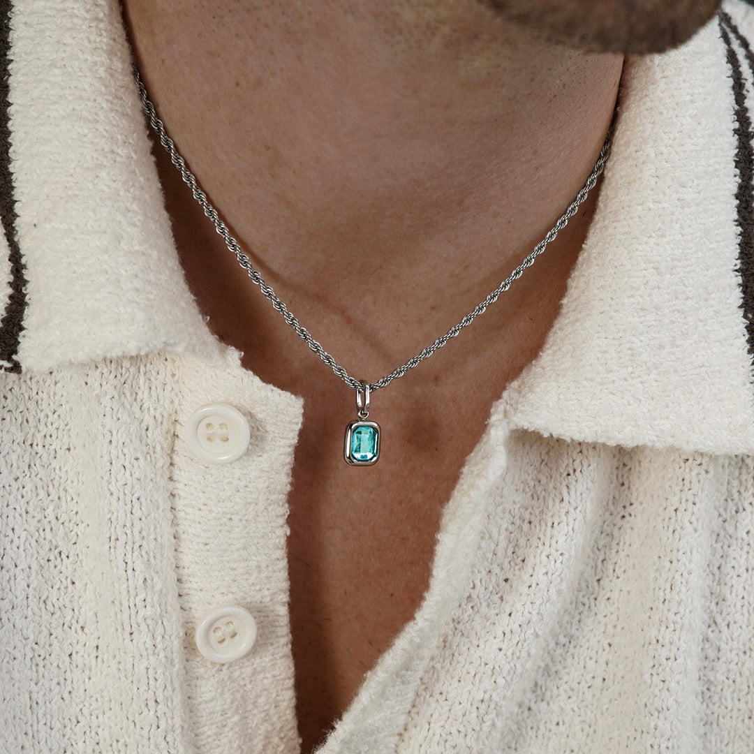 FRNE glacier blue gemstone silver pendant necklace worn by a person, featuring a rectangular light blue stone on a silver chain styled with a textured cream shirt
