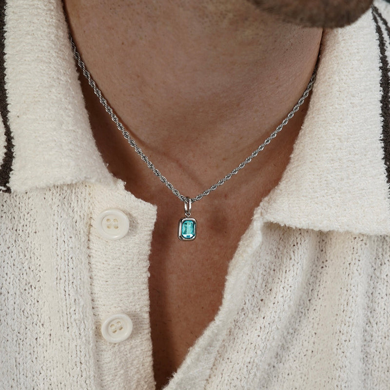 FRNE glacier blue gemstone silver pendant necklace worn by a person, featuring a rectangular light blue stone on a silver chain styled with a textured cream shirt