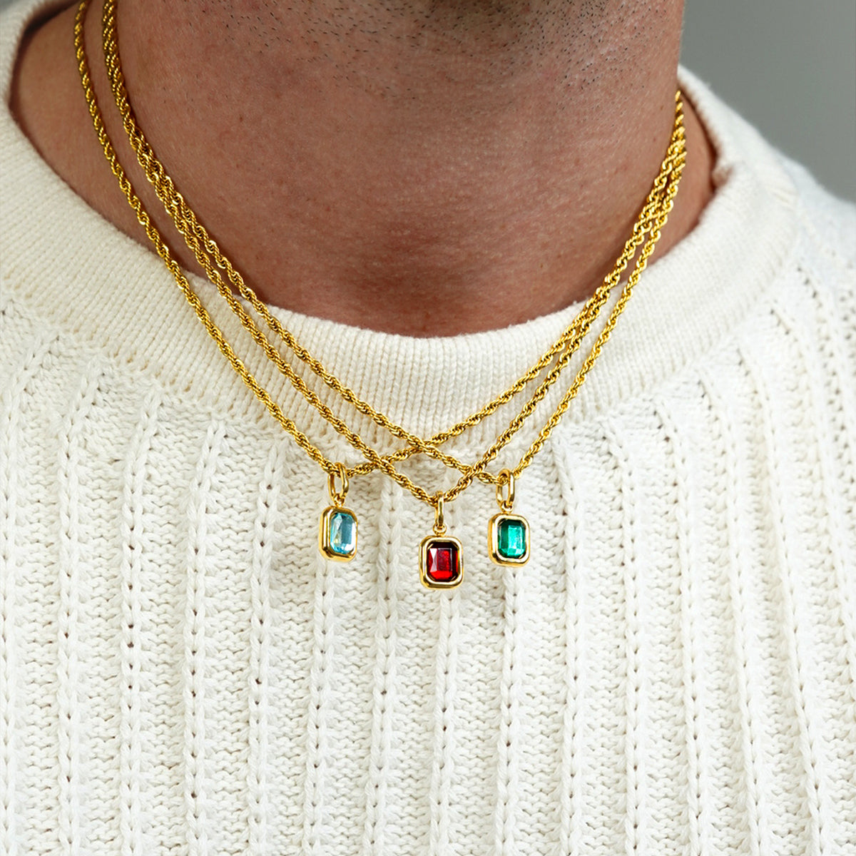 FRNE gold multi layered necklaces with blue red and green gemstone pendant charms worn on neck with white sweater