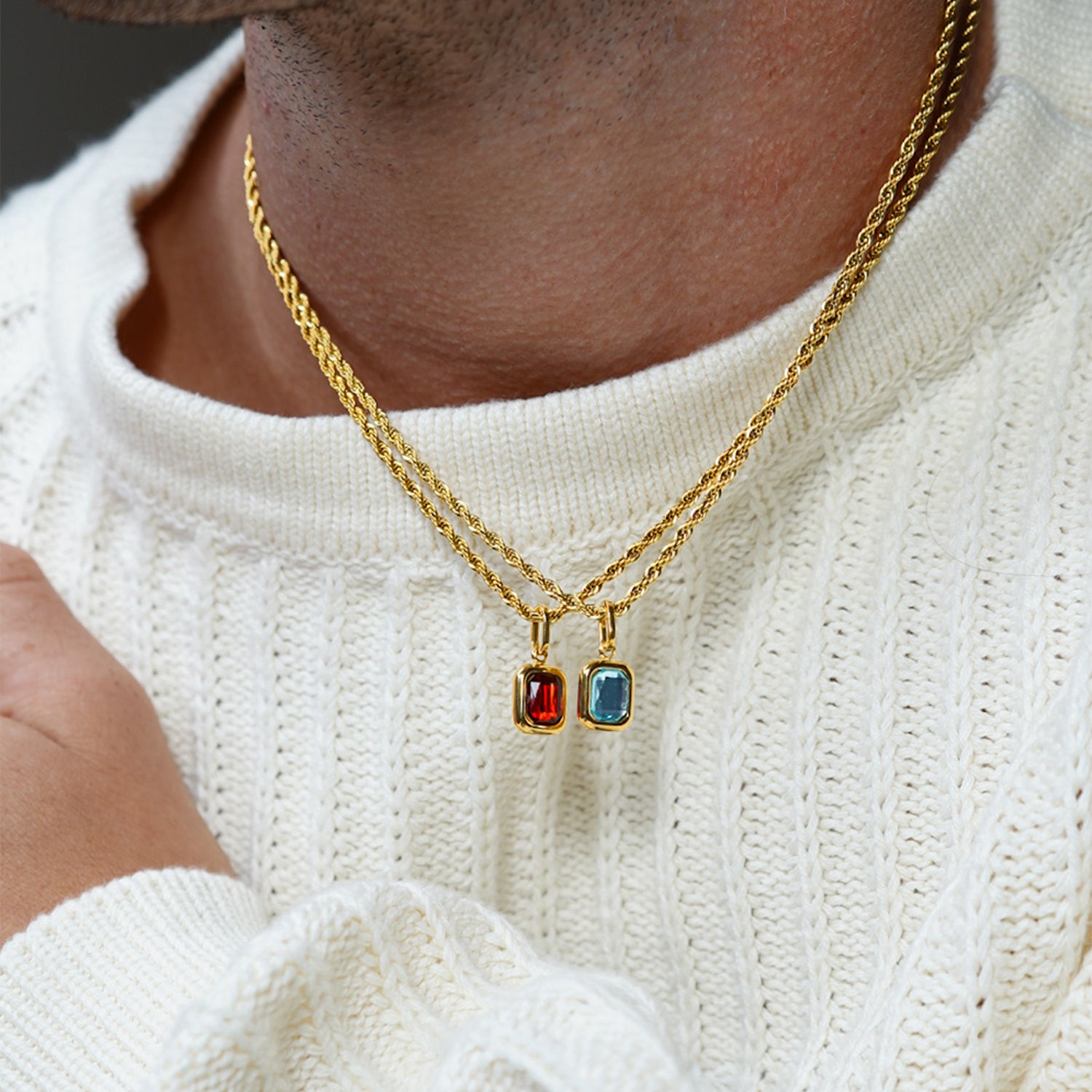 FRNE gold layered necklaces with red and blue gemstone pendant charms worn on neck with white sweater