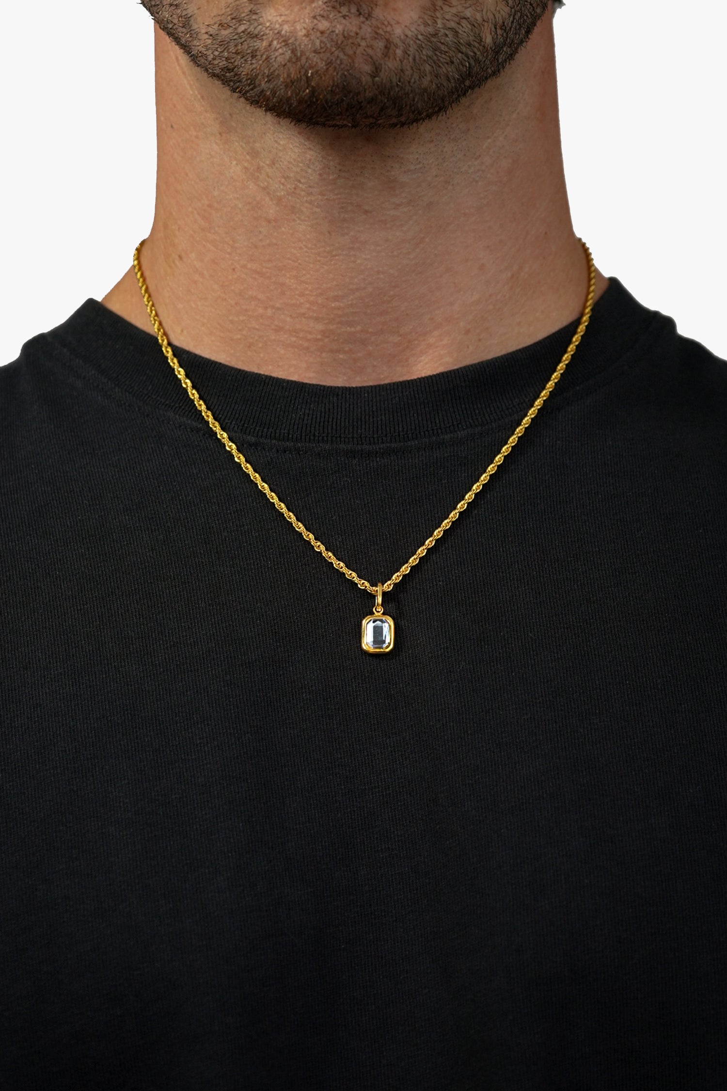 FRNE gold tanzanite pendant necklace with blue gemstone worn on neck with black shirt close up