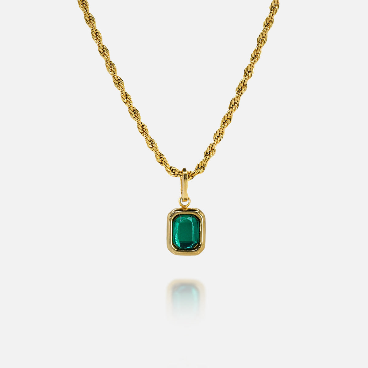 FRNE lucky gem green gemstone gold necklace featuring a rectangular emerald-green pendant set in a gold frame on a gold chain, displayed on a clean white background with a subtle reflection below