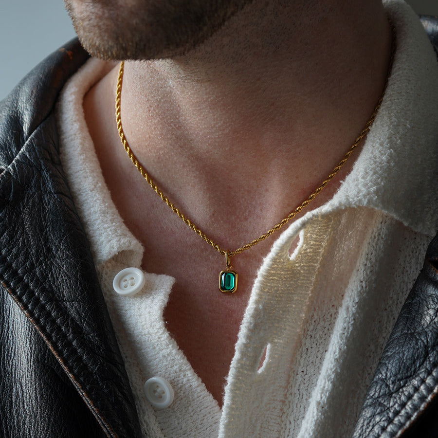 FRNE lucky gem green gemstone gold necklace worn by a person, featuring a rectangular emerald-green pendant on a gold chain, styled with a white shirt and black leather jacket in a close-up portrait
