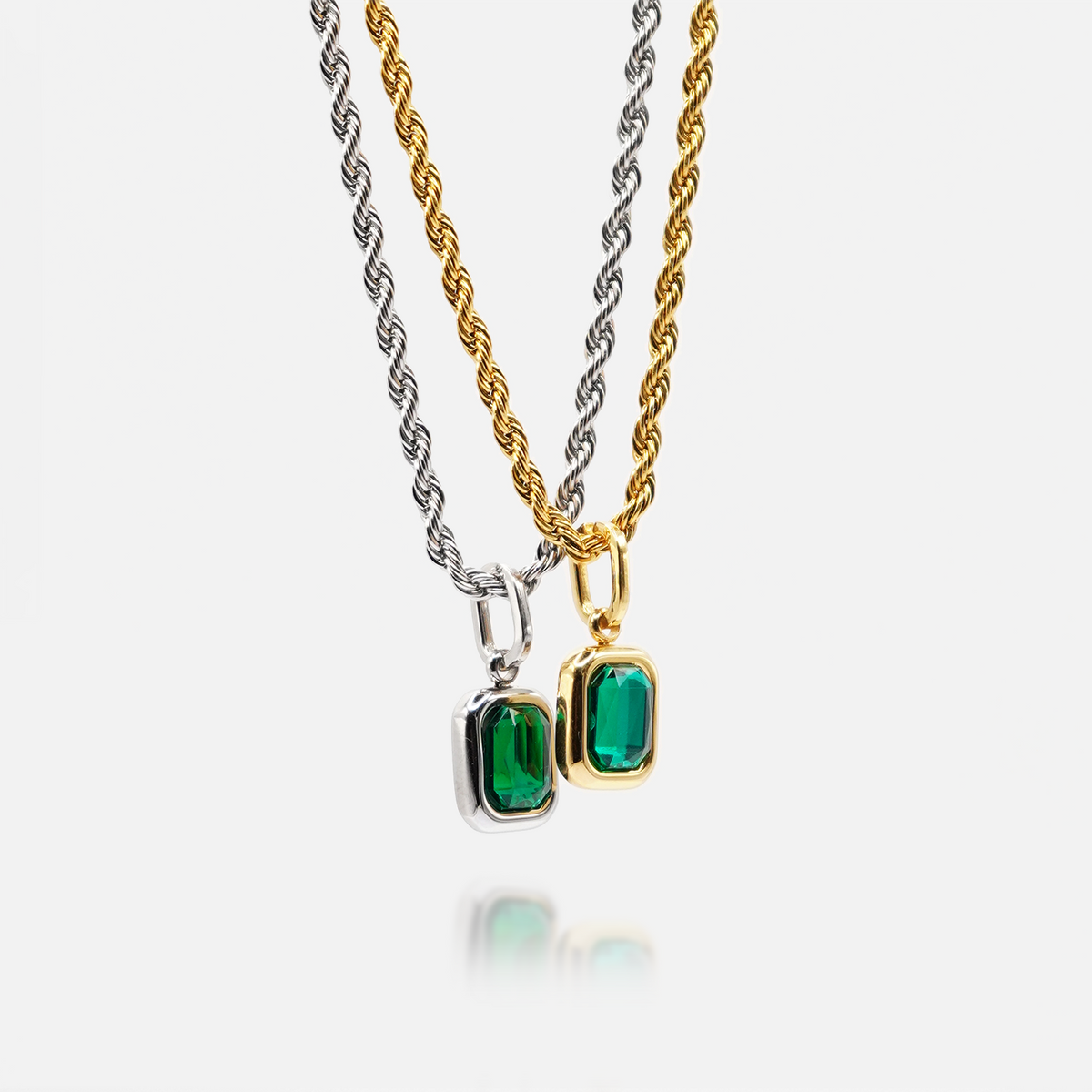 FRNE lucky gem green gemstone necklaces in gold and silver, featuring two rectangular emerald-green pendants on matching chains, displayed side by side on a clean white background with a subtle reflection