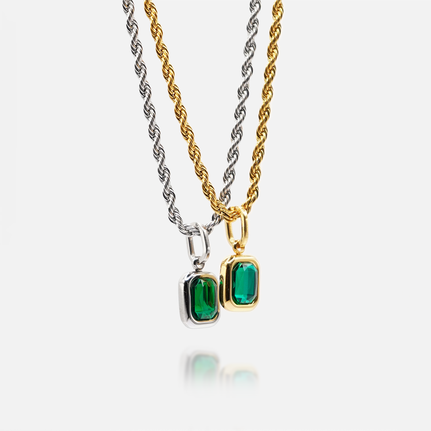 FRNE lucky gem green gemstone necklaces in gold and silver, featuring two rectangular emerald-green pendants on matching chains, displayed side by side on a clean white background with a subtle reflection