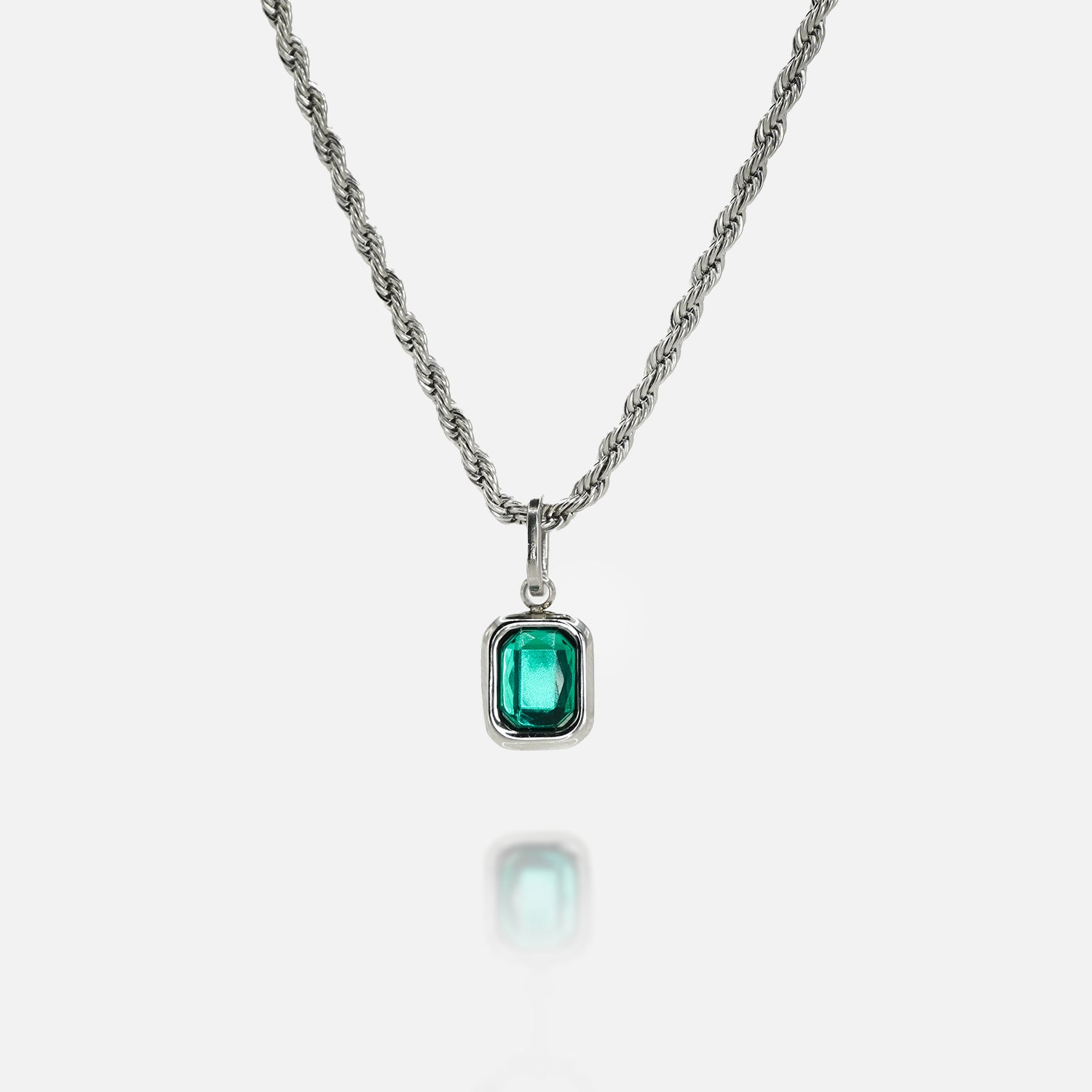Silver necklace with a rectangular green gemstone pendant on a clean white background, featuring a reflective surface below the pendant