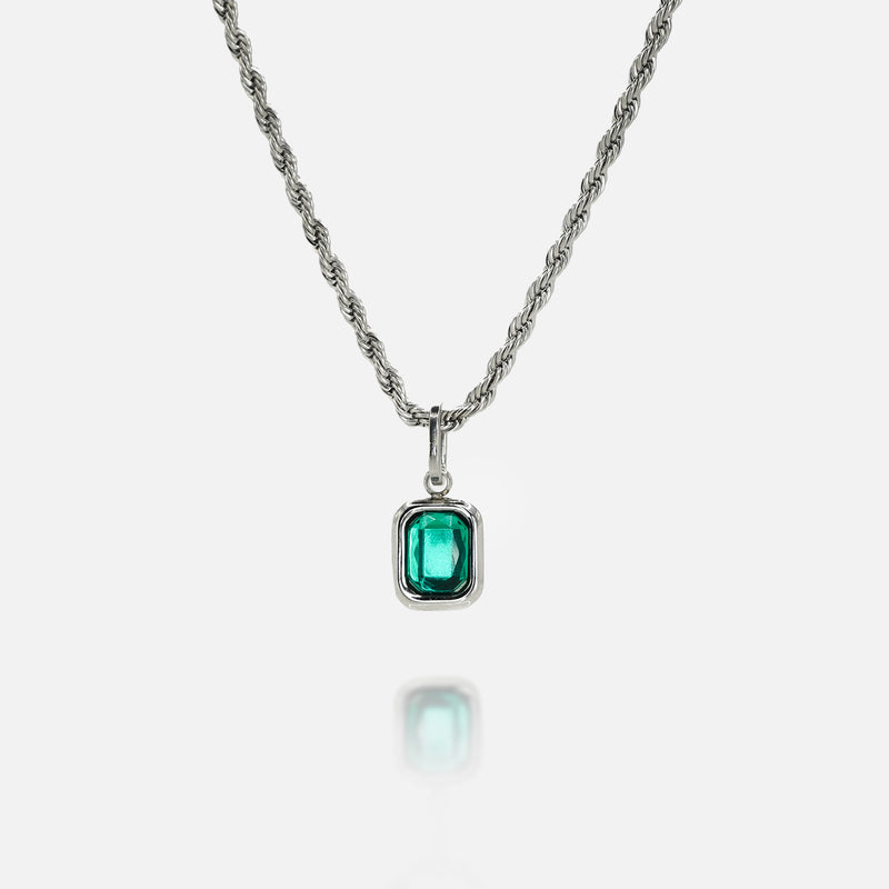 Silver necklace with a rectangular green gemstone pendant on a clean white background, featuring a reflective surface below the pendant