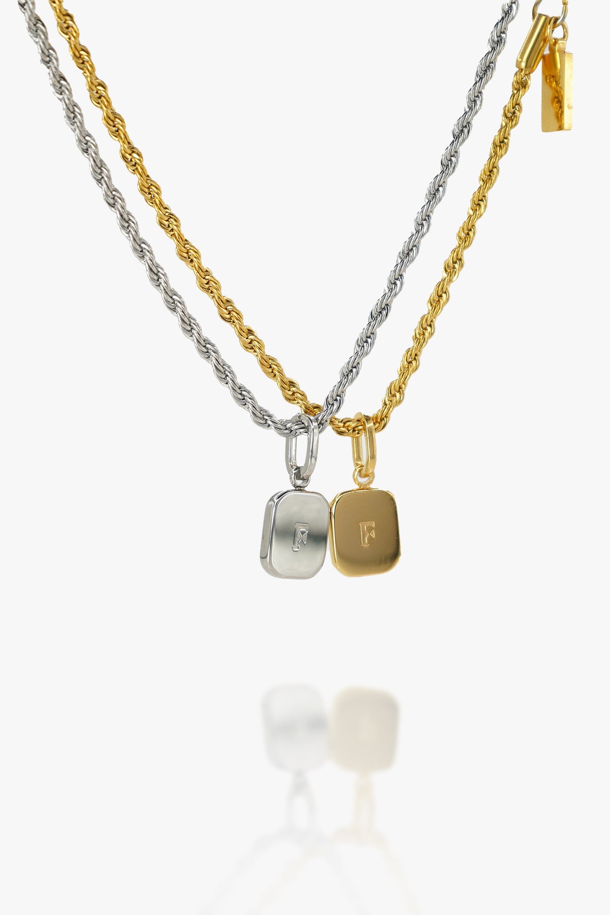 Gold and sterling silver initial pendant necklaces with engraved letter charms on white background