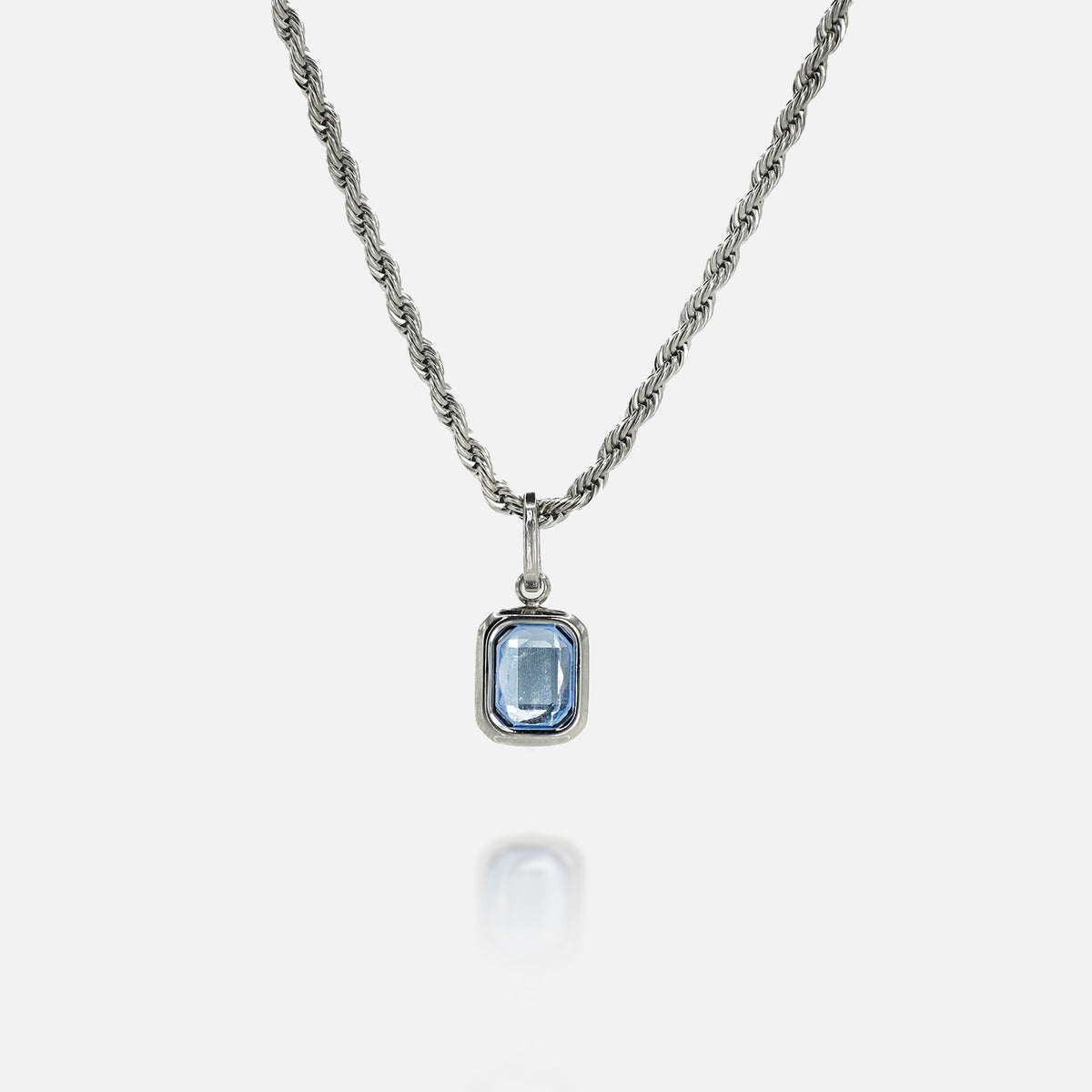 Sterling silver necklace with rectangular blue tanzanite gemstone pendant on white background