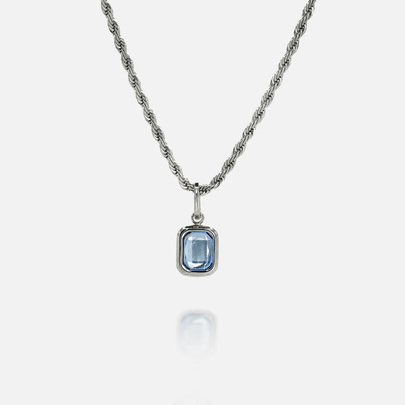 Sterling silver necklace with rectangular blue tanzanite gemstone pendant on white background